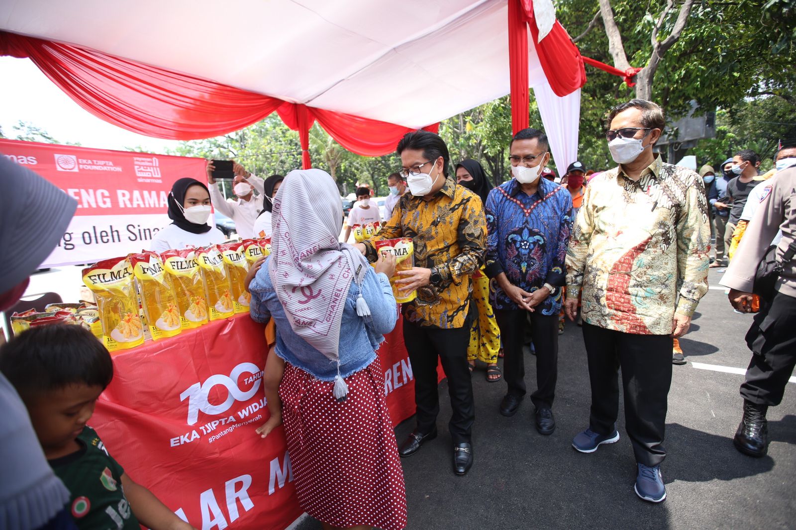 Managing Director Sinar Mas, Ferry Salman (batik kuning) dan Saleh Husin (batik biru) menyerahkan secara simbolis minyak goreng ke masyarakat ditemani oleh Menteri Koordinator Politik, Hukum dan Keamanan, Mohammad Mahfud MD (kanan) dalam bazar yang berlangsung di kantor Kemenkopolhukam